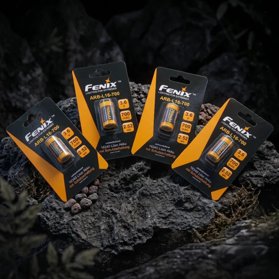 Fenix baterijos originaliose pakuotėse ant akmenų